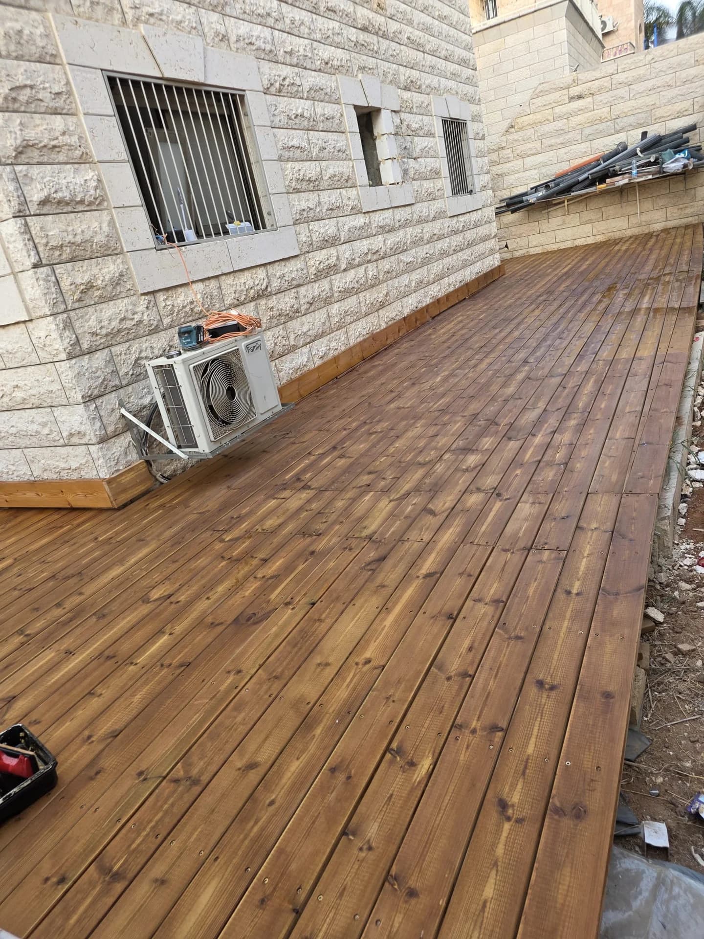 פרויקט דק עץ איפה מאופן בחצר בית פרטי עם חיפוי אבן ירושלמית, התקנה מקצועית של ע.ד.ר.כ