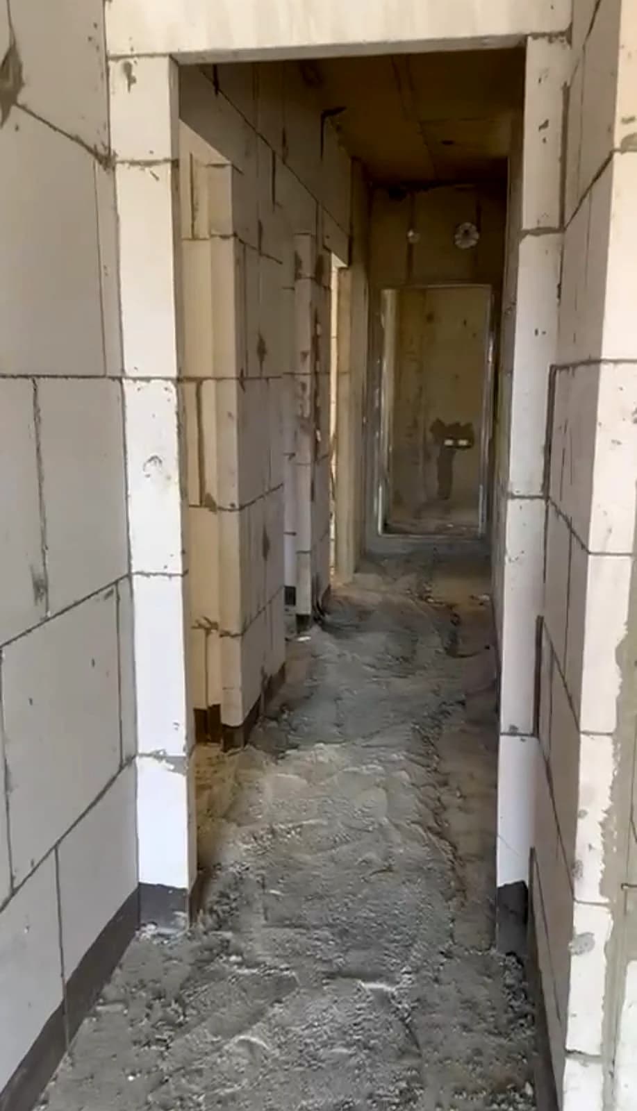מסדרון פנימי בבית בבנייה עם קירות איטונג לבנים, פתחי דלתות מוכנים, שלב לפני טיח