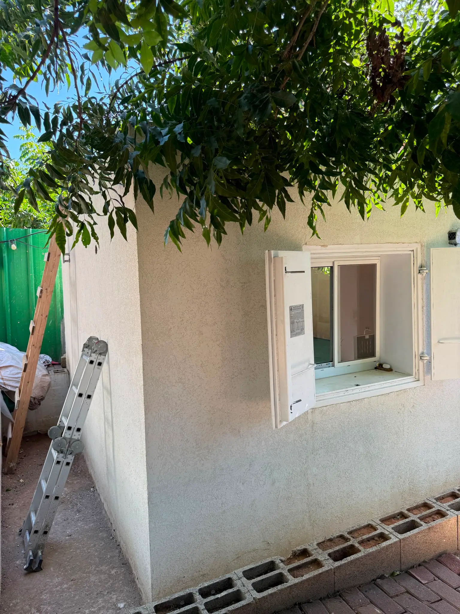 מבט נוסף על חלון ההדף ותריס המיגון הפתוח של הממ"ד, גימור טיח חיצוני