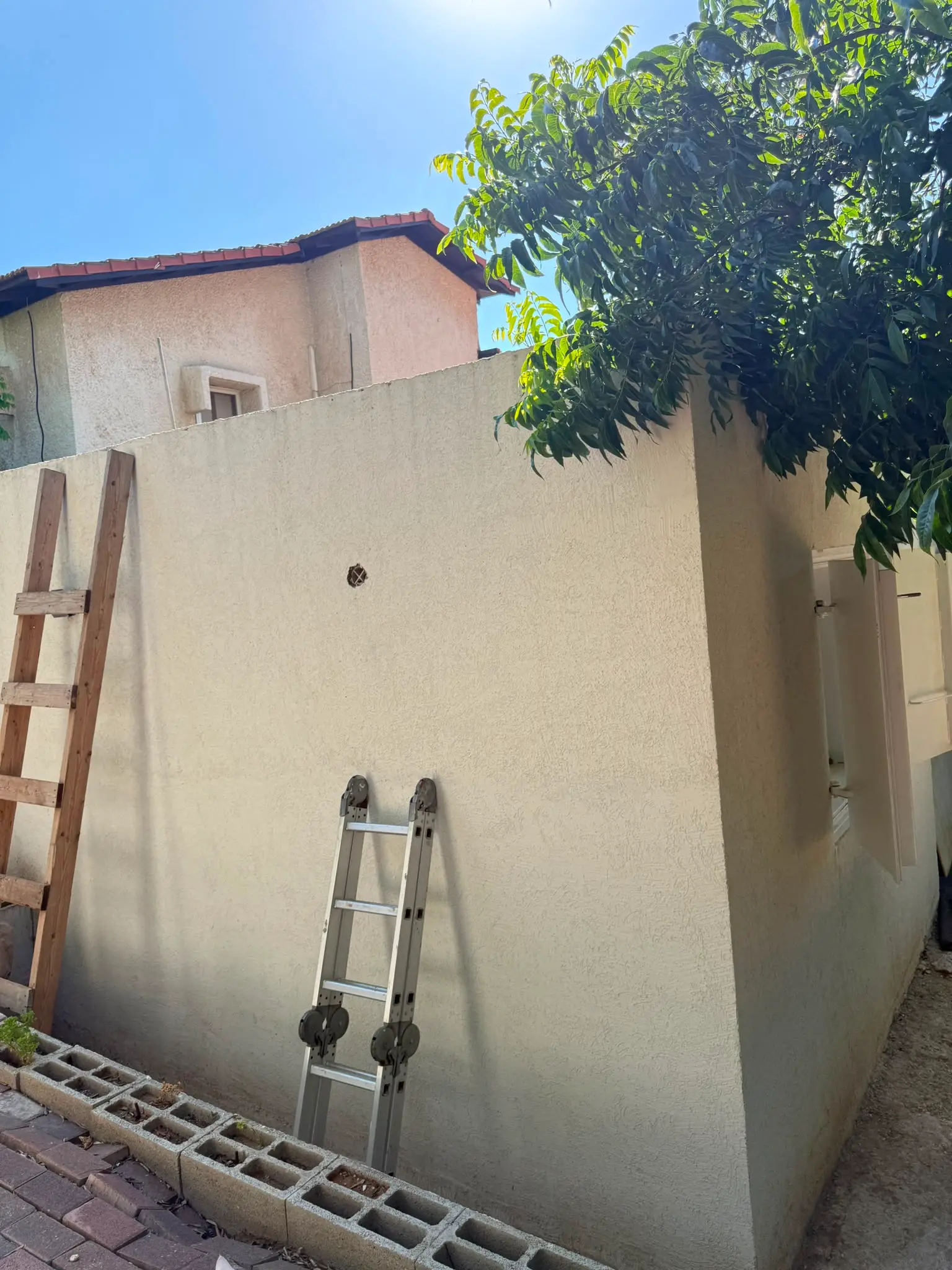 קיר חיצוני של הממ"ד בשלב גימור, סולם עבודה צמוד לקיר, בית פרטי ברמת רזיאל