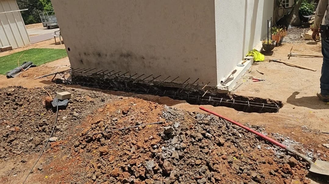 חפירת יסודות עם רשת ברזל זיון מחוזק, צמודים לקיר בית קיים, שלב לפני יציקה