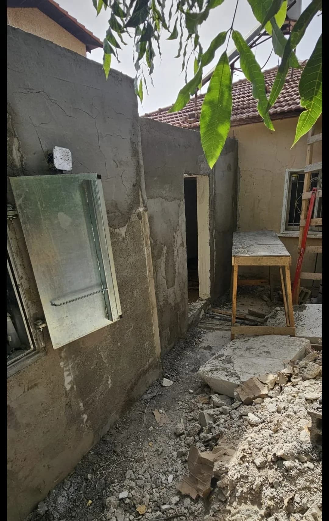 מבט על שלד בלוקים של תוספת חדר לבית פרטי, טיח מלא, חלון פתוח לפני התקנת מסגרת